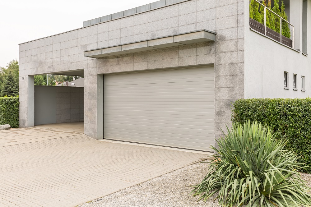 Big grey house with a drive way and a parking garage