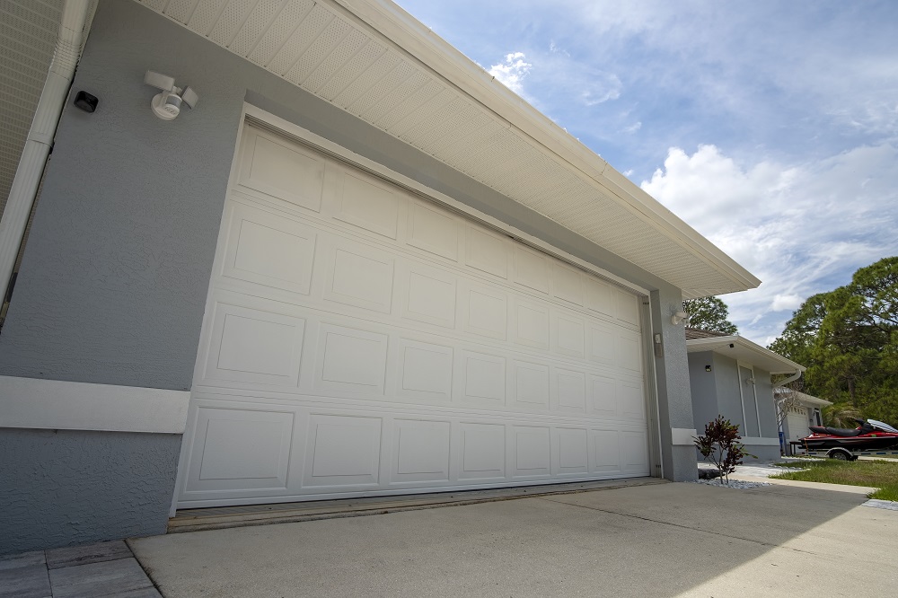 Wide garage double door and concrete driveway of new modern american house.