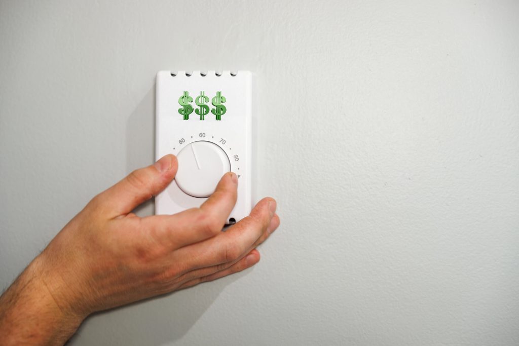 Hand Adjusting Thermostat to Save on Heating and cooling Cooling