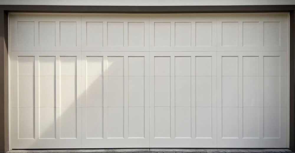 A clean and white garage door in a residential area after the renovation
