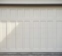 A clean and white garage door in a residential area after the renovation