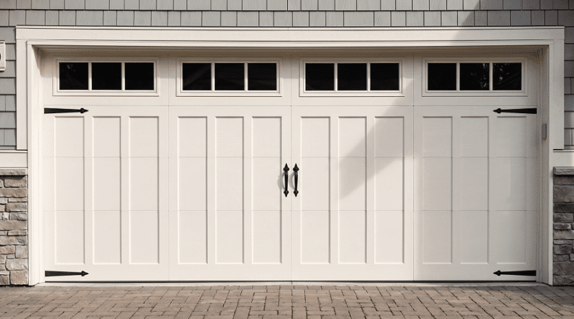 Clean white carriage-style residential garage door with black hinges and glass panels installed by Select Garage Doors