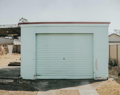 Older mint green garage door showing years of seasonal wear